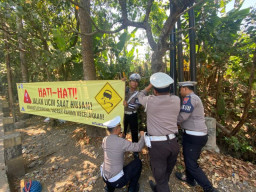 Anggota Satlantas Polres Batu Pasang Spanduk di Lokasi Rawan Kecelakaan dan Bencana