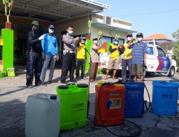 Babinkamtibmas Polsek Balongbendo Bantu Warga Semprot Disinfektan