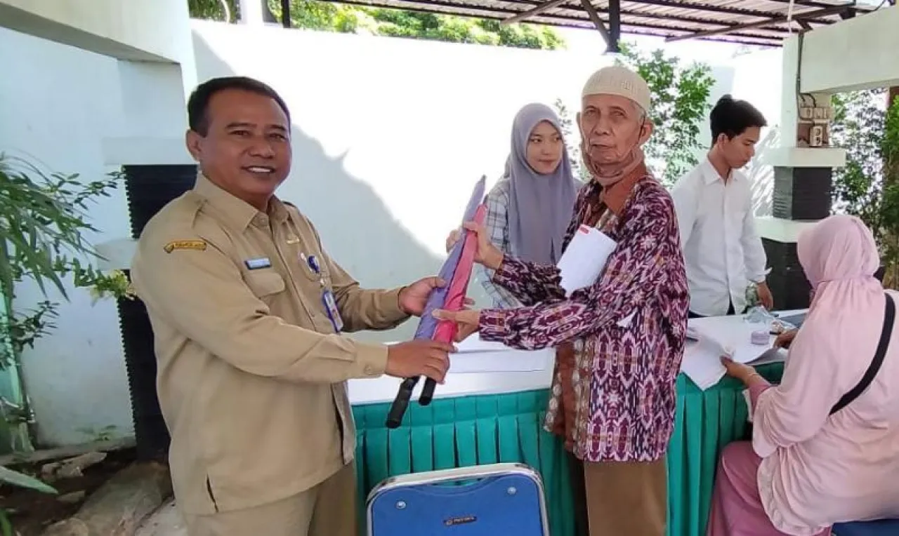 Kepala Bapenda Kota Madiun, Jarianto menyerahkan souvenir kepada wajib pajak yang telah melunasi PBB.