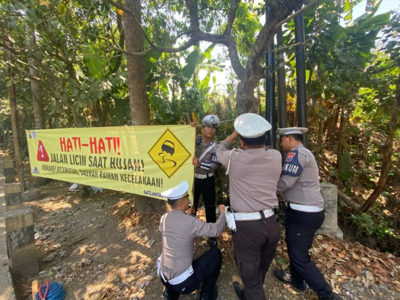 Anggota Satlantas Polres Batu Pasang Spanduk di Lokasi Rawan Kecelakaan dan Bencana