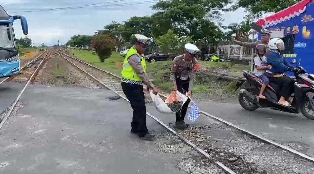Polresta bersama petugas KA bahu membahu perbaiki jalan rusak. (Foto: Humas)
