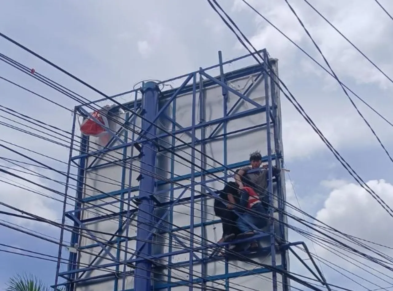 Diduga Tersetrum, Pria Tak Sadarkan Diri di Atas Baliho Simpang Empat