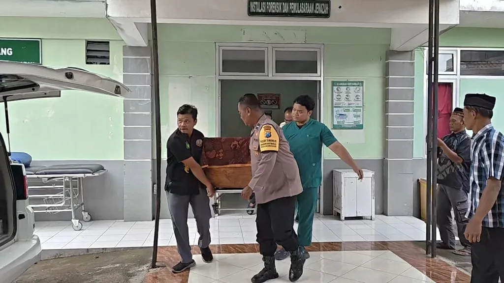 Petugas kamar jenazah RSUD Harjono Ponorogo saat memasuki peti jenazah Toni ke ambulans.  Foto: Zainul